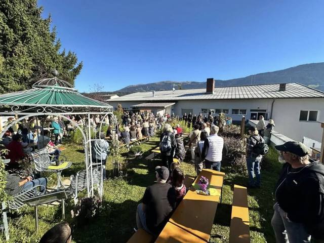 Zahlreiche Gäste auf Bierbänken und im Garten bei der Eröffnungsfeier des Igel-Lehrpfads